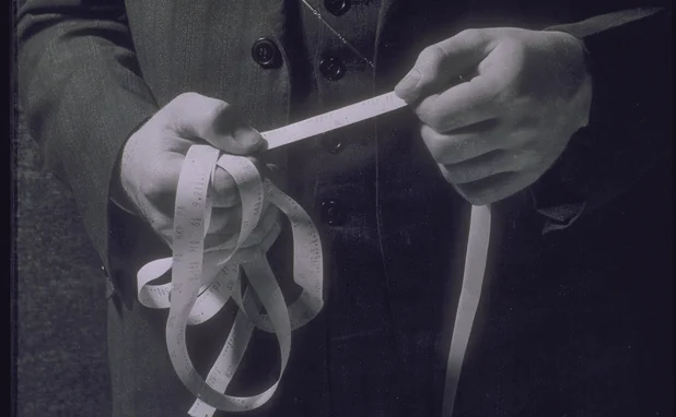 Man holding ticker tape showing stock prices