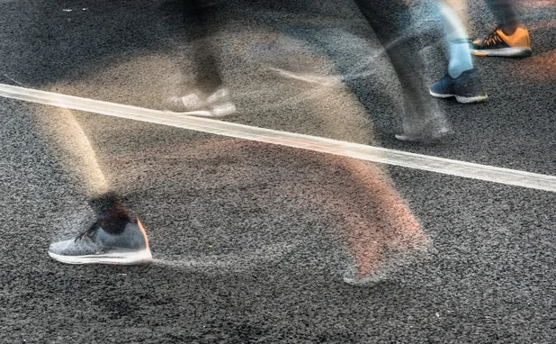 People running in marathon on city streets. Motion blur.