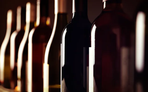 Bottles of old aged wine collection in a row in winery cellar