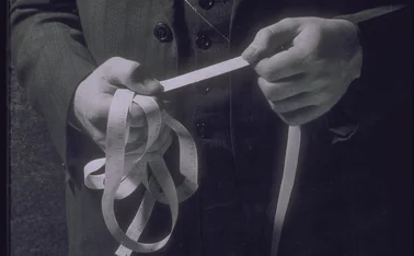 Man holding ticker tape showing stock prices