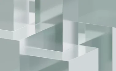 Abstract composition of stacked, interlocking geometric blocks in pale grey and muted sage green, with clean lines and soft shadows.