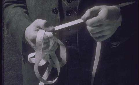 Man holding ticker tape showing stock prices