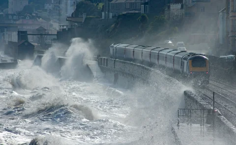 High speed train leaving Dawlish in a storm - stock photo
