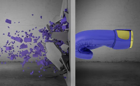 Blue boxing glove breaking through a concrete wall, symbolizing overcoming challenges and strength