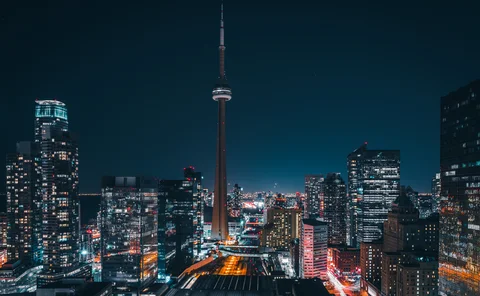Futuristic and modern skyline views of downtown Toronto with the train tracks leading your eye to office buildings and condominiums.