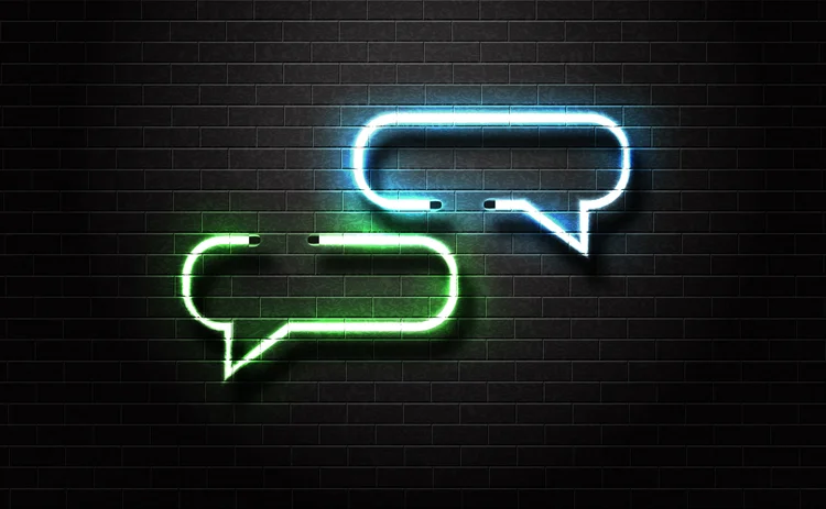 neon chat bubbles over dark brick wall