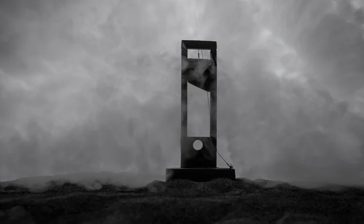 Close-up of a guillotine on a dark foggy background. Execution concept