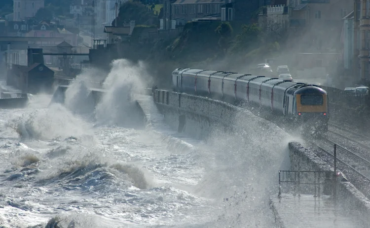 High speed train leaving Dawlish in a storm - stock photo
