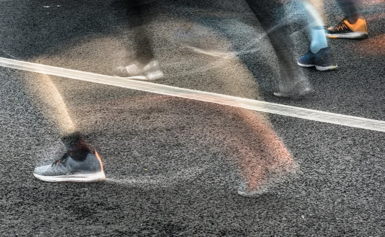 People running in marathon on city streets. Motion blur.