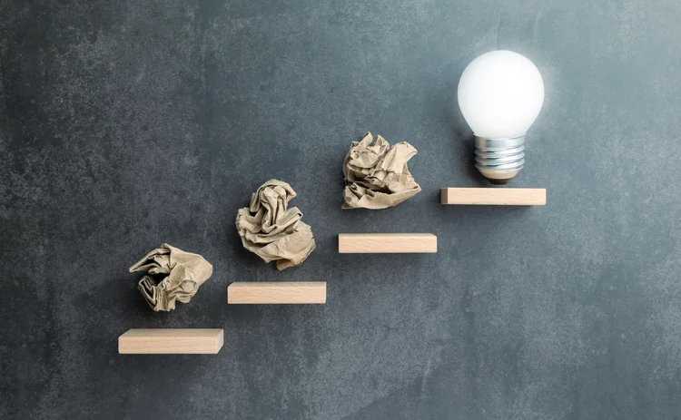 Steps with trash leading to a lightbulb