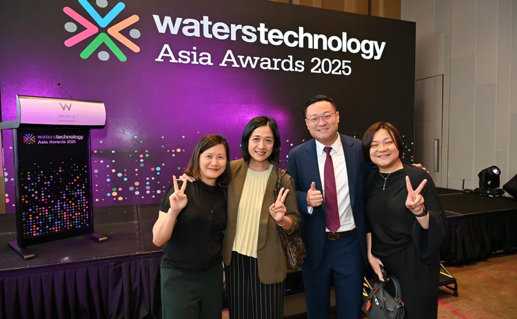Group of people standing infront of the waterstechnology asia awards banner