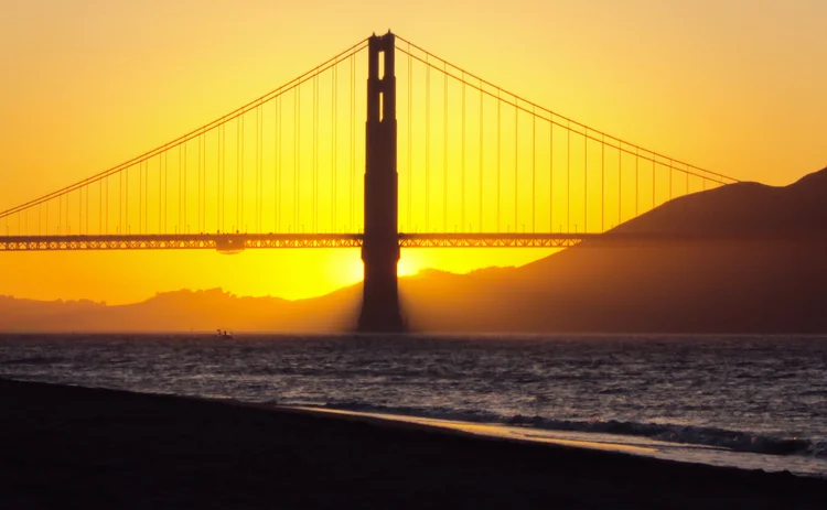 The sun sets over San Francisco Bay and the Golden Gate Bridge