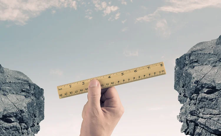 A hand measuring a gap with a ruler A hand measuring a gap with a ruler