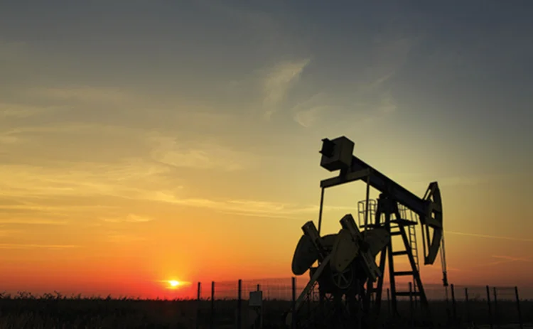 Photo of an oil derrick at sunset