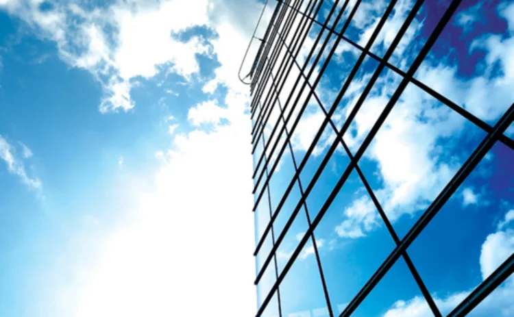 An office building with a cloudy sky in the background