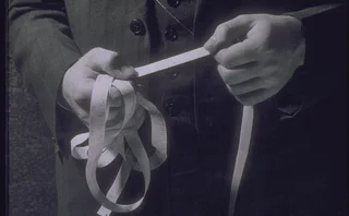 Man holding ticker tape showing stock prices