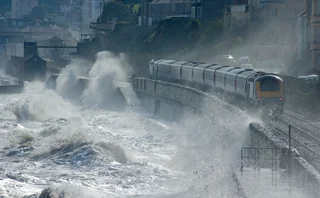 High speed train leaving Dawlish in a storm - stock photo