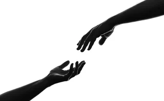 The silhouette of hands reaching out to each other - stock photo