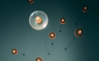Modern cluster of glass globe pendant lights with exposed filament bulbs providing warm ambient lighting in a high-ceiling room
