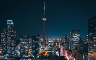 Futuristic and modern skyline views of downtown Toronto with the train tracks leading your eye to office buildings and condominiums.