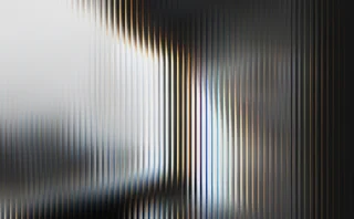 Abstract image of vertical blurred light streaks in white, black, blue and warm gold tones, creating a high-contrast, layered gradient effect