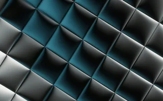 Abstract geometric background featuring a repeating pattern of metallic black, silver and teal-blue triangular shapes with reflective lighting, creating a three-dimensional, faceted surface for modern technology, digital innovation and corporate design themes