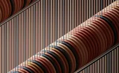 Abstract geometric artwork with stacked circular discs and vertical lines in earthy tones of red, brown, beige and black, creating a modern architectural pattern.