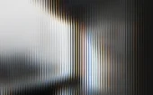 Abstract image of vertical blurred light streaks in white, black, blue and warm gold tones, creating a high-contrast, layered gradient effect