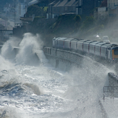 High speed train leaving Dawlish in a storm - stock photo