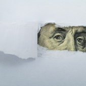 Torn white paper revealing US Currency - stock photo