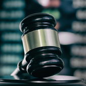 Gavel against a trading screen